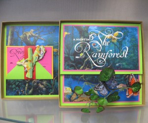 8” square custom kraft box holds a full color rainforest scene with white invitation print inside, detailed with bendable stems holding leaves and butterflies which pop up as box is opened
