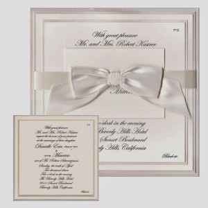 8.5 square Ecru cotton/pearl frost invitation slides into satin ribbon-banded jacket finished with bow